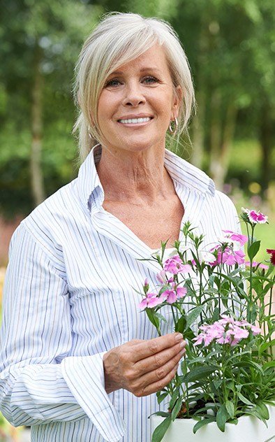 Senior woman outdoors holding flowers